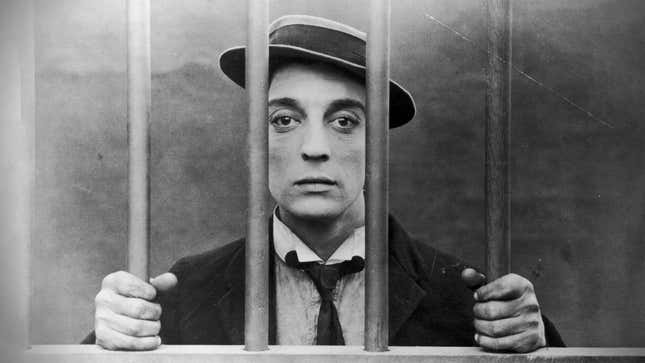 Buster Keaton is shown holding onto prison bars with a sad expression.